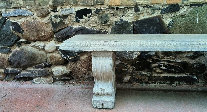 Stone bench by stone wall