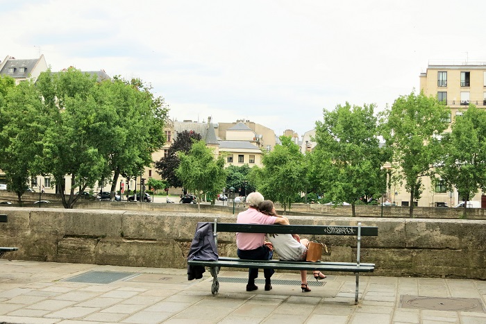 Couple relaxing on a bench in L'Ile Saint Louis in Paris