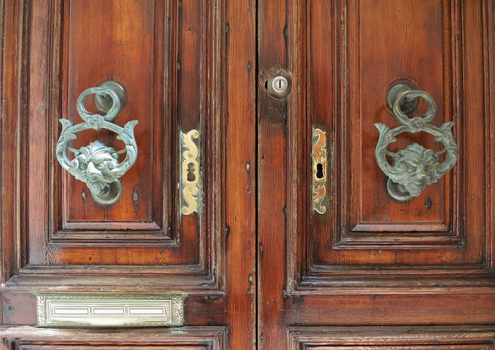 Bronze mythical creature knocker on wood door, Malta