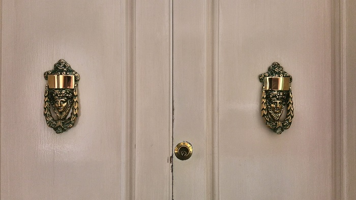 Brass Bacchus face knocker on cream door, Gozo